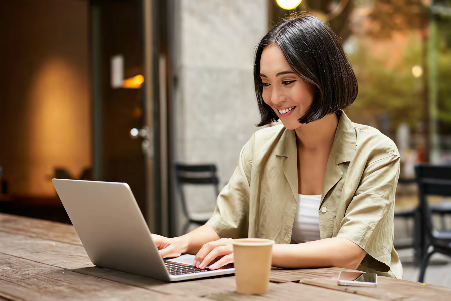 Professional smiling while analyzing SEO performance on a laptop.